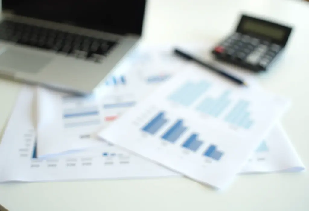 Novo limite de faturamento MEI: Fuja da malha fina em 2024 Documentos financeiros e calculadora em uma mesa organizada, representando o faturamento MEI